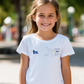A young girl wearing white t-shirt with TeeMemento embroidered and personalised message for athletics stars