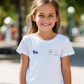 Young girl wearing a white t-shirt with logos outdoors showcasing a TeeMemento product