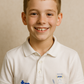 Young boy wearing a white polo shirt with logos on a beige background showcasing a TeeMemento product