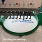 Embroidery machine with a message on a white fabric, featuring the brand 'teememento'.