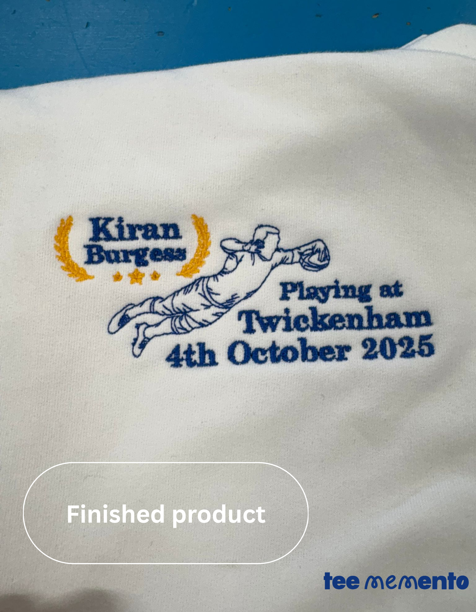 Embroidered design on a white fabric with text 'Kiran Burgess Playing at Twickenham 4th October 2025' and 'TeeMemento' branding.